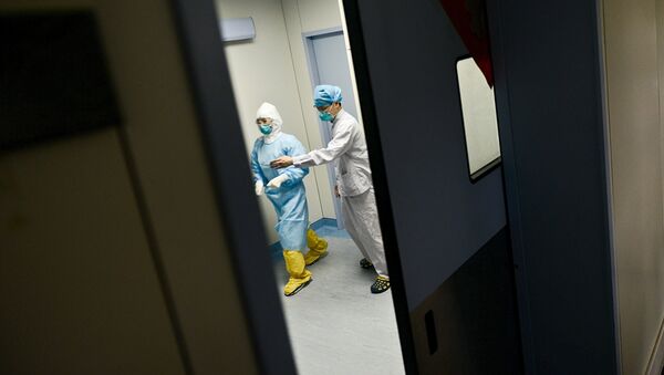 Medical personnel walk past inside the door of an ICU room at a hospital where a South Korean MERS patient is being quarantined and treated, in Huizhou, Guangdong province, China, June 1, 2015. - Sputnik Mundo