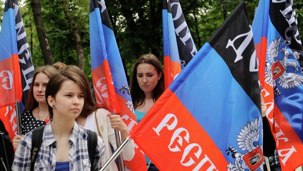 Representantes de la República Popular de Donetsk con las banderas de su república - Sputnik Mundo