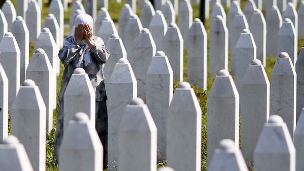 A woman prays near the grave of her relative, among 136 newly identified victims of the 1995 Srebrenica massacre - Sputnik Mundo