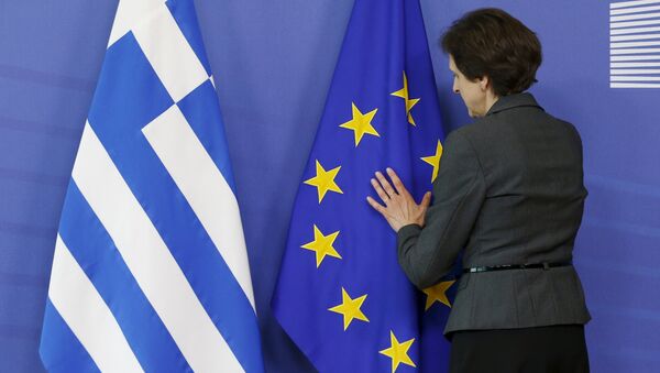 Una mujer ajusta las banderas de UE y Grecia - Sputnik Mundo