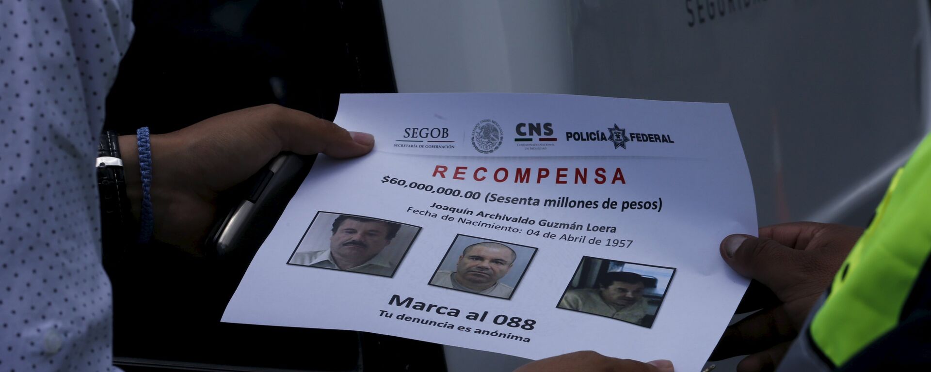 A federal police (R) hand out flyers to driver with photos of drug lord Joaquin El Chapo Guzman - Sputnik Mundo, 1920, 06.11.2021