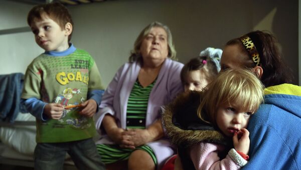 A Refugee family from a city in the Donetsk region controlled by pro-Russia separatists sit together in a center for refugees in the eastern Ukrainian city of Slavyansk, which is controlled by Ukrainian forces on March 12, 2015. - Sputnik Mundo