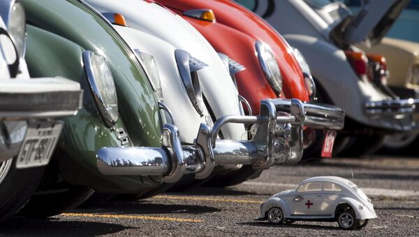 Игрушечная машинка Volkswagen Beetle перед автомобилями-жуками во время праздника в Сан-Бернарду-ду-Кампу - Sputnik Mundo