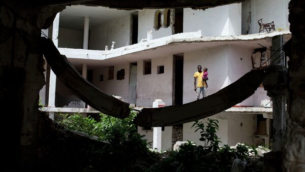 Un padre sostiene a su hija fuera de su habitación en Puerto Príncipe - Sputnik Mundo