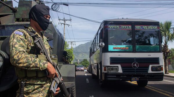 A soldier guards a street as a passenger bus drives past, in San Salvador, El Salvador, Wednesday, July 29, 2015 - Sputnik Mundo