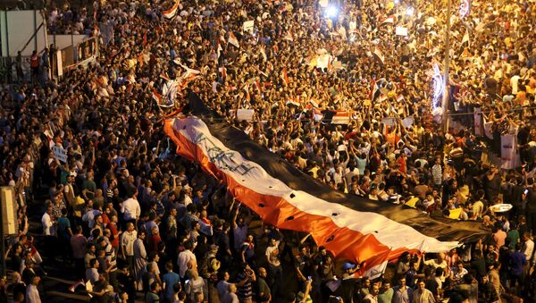 Iraquíes llevan la bandera nacional durante manifestación - Sputnik Mundo