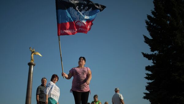 Representantes de la República Popular de Donetsk con las banderas de su república - Sputnik Mundo