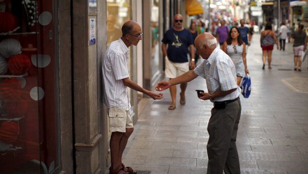 Un hombre da limosna a un mendigo en la ciudad de Ronda, España - Sputnik Mundo