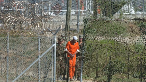 A detainee is escorted to interrogation by U.S. military guards at Camp X-Ray at Guantanamo Bay. - Sputnik Mundo