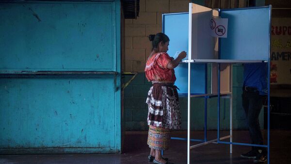 Una mujer marca su voto en un centros de votación en la ciudad de Guatemala - Sputnik Mundo