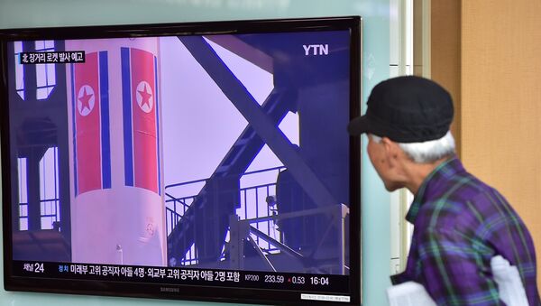Un anciano ve las noticias sobre las reparaciones para el lanzamiento de un cohete norcoreano - Sputnik Mundo