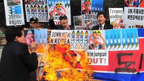 Activistas conservadores de Corea del Sur abrasan la bandera de Corea del Norte como una protesta contra los cohetazos - Sputnik Mundo