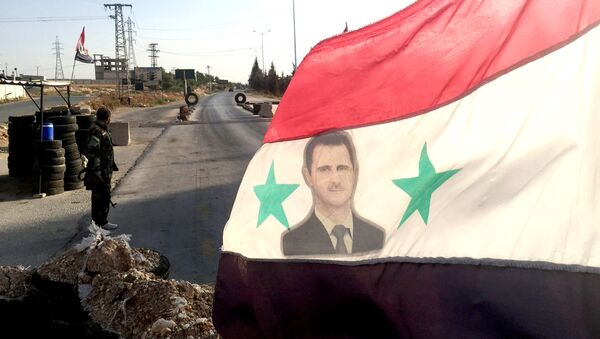 Bandera con una imagen de Bashar Asad - Sputnik Mundo