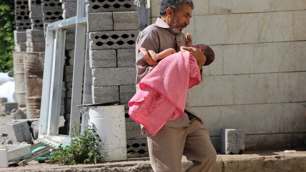 Un hombre lleva a su hija herida al hospital en la ciudad yemení de Taiz - Sputnik Mundo