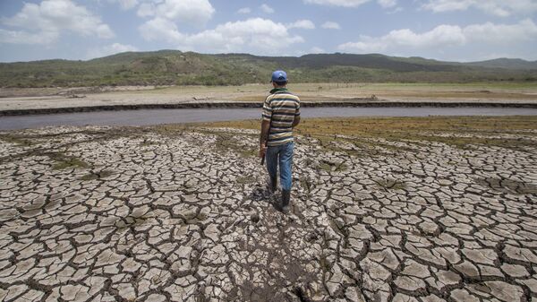 A man crosses the reservoir of Las Canoas, 60 km from Managua, on his way home - Sputnik Mundo