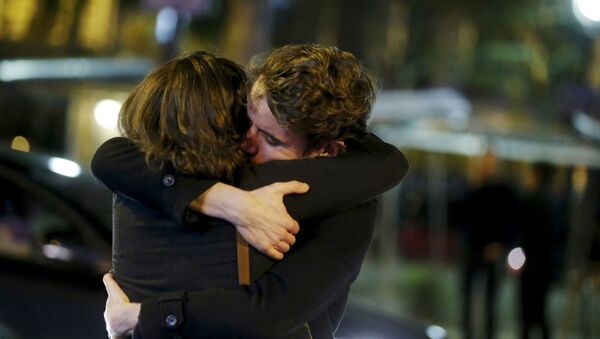 People hug on the street near the Bataclan concert hall following fatal attacks in Paris, France, November 14, 2015 - Sputnik Mundo