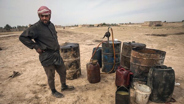 Un hombre trabaja en una refinería de petróleo improvisada en Raqqa, Siria - Sputnik Mundo