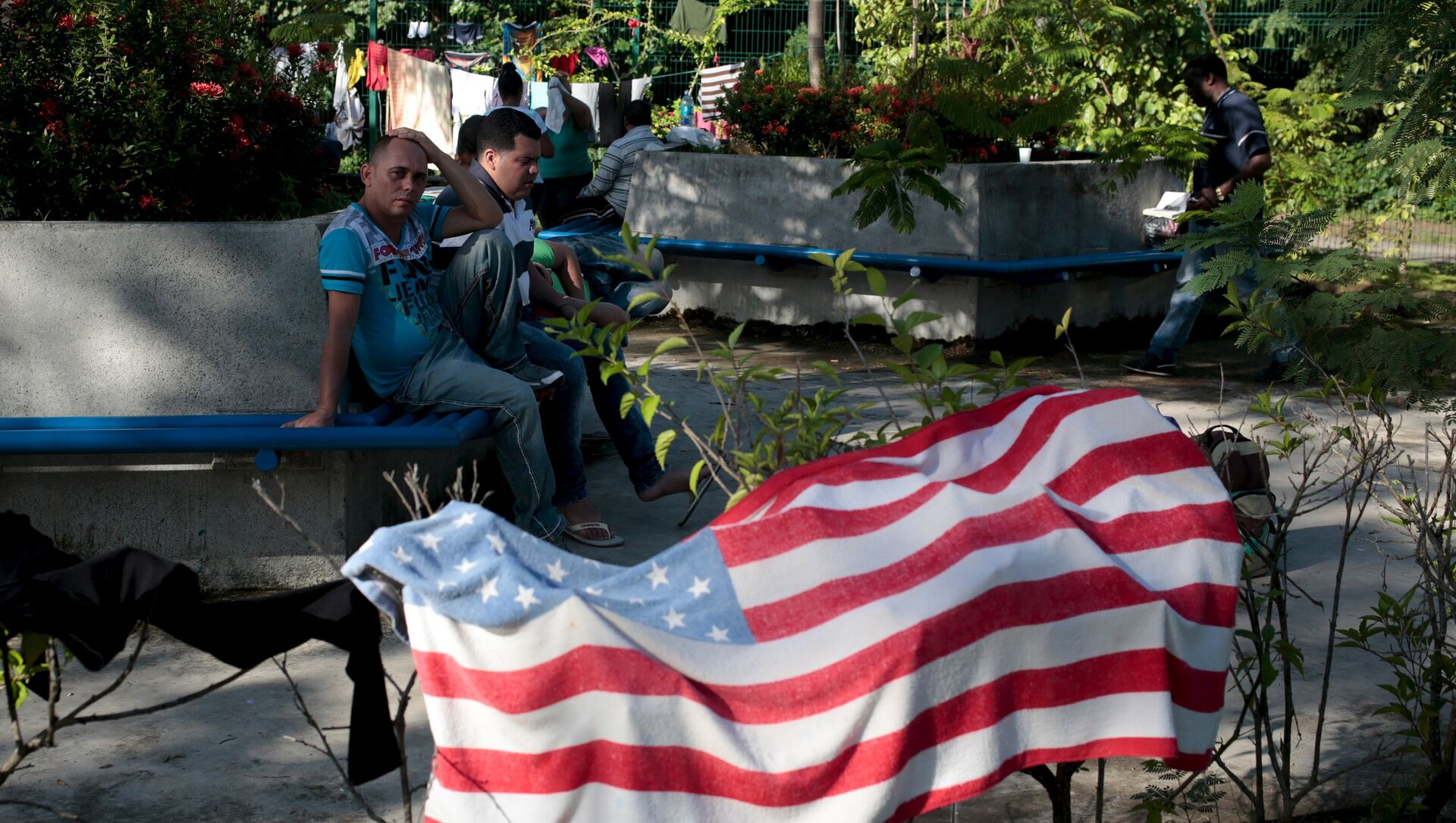 Cuban migrants sit near a beach towel with the U.S. flag - Sputnik Mundo, 1920, 04.02.2021