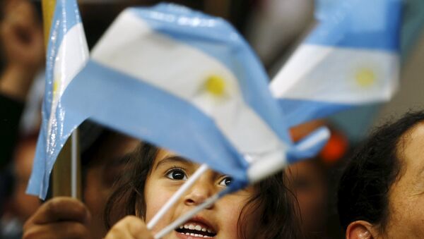 A child waves Argentine national flags during the final campaign rally of Argentina's ruling party candidate Daniel Scioli in La Matanza, on the outskirts of Buenos Aires, November 19, 2015. - Sputnik Mundo