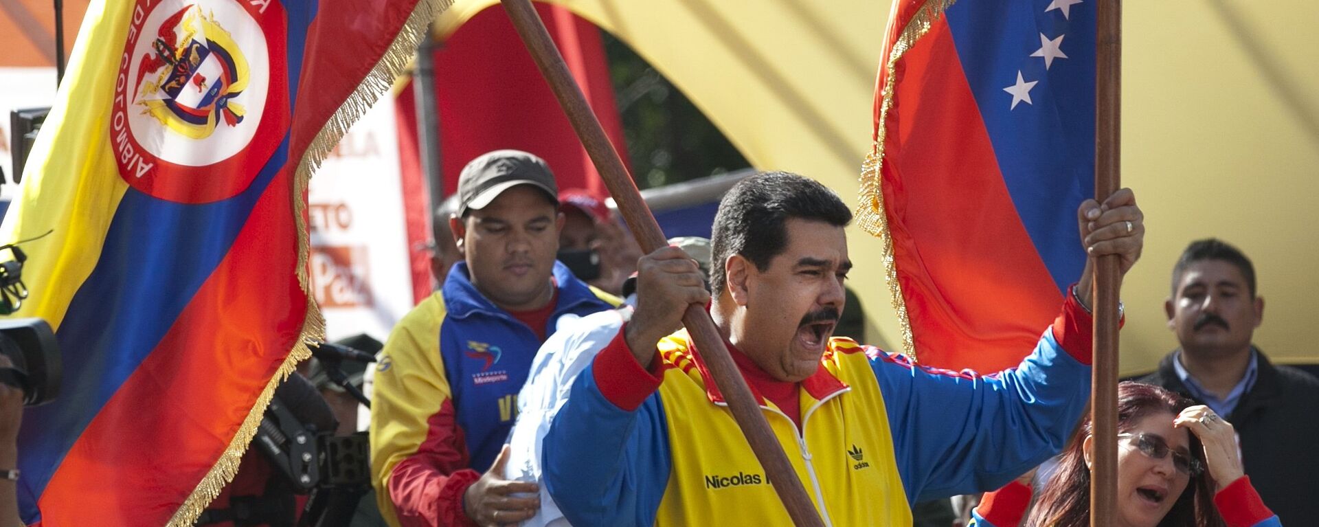 Venezuela's President Nicolas Maduro holds up a Colombian national flag, left, alongside his country's national flag, during a rally in support of closing the Colombian border, in Caracas, Venezuela, Friday, Aug. 28, 2015. - Sputnik Mundo, 1920, 08.08.2022
