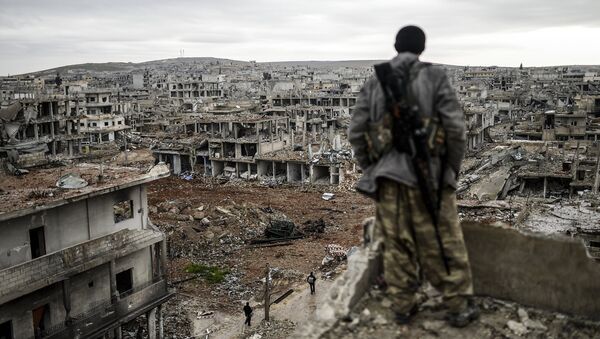 Un kurdo está en el edificio mirando a la destruida ciudad de Kobane, conocida como Ain al-Arab, en enero del 2015 - Sputnik Mundo