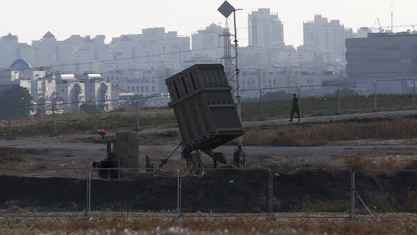 An Israeli soldier walks past an Iron Dome battery, a short-range missile defence system, designed to intercept and destroy incoming short-range rockets and artillery shells, on August 20, 2015, in the city of Ashdod. - Sputnik Mundo