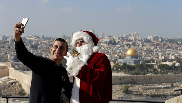 Un hombre se hace un selfie con Papá Noel en Jerusalén - Sputnik Mundo