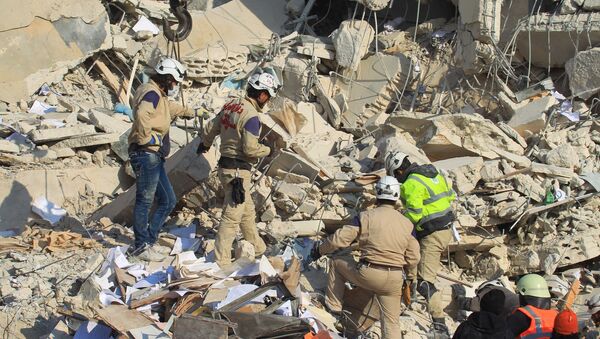 Civil defense members search for survivors at a site hit yesterday by what activists said were airstrikes carried out by the Russian air force in Idlib city, Syria - Sputnik Mundo