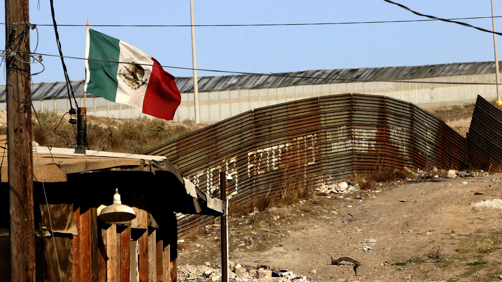 A Mexican flag waves close to the wall which separates Mexico from the United States 24 January 2006, in Tijuana, state of Baja California - Sputnik Mundo, 1920, 02.02.2022