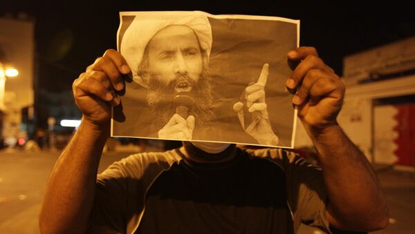 Un manifestante lleva la imagen del clérigo chií Nimr Baqir al Nimr - Sputnik Mundo