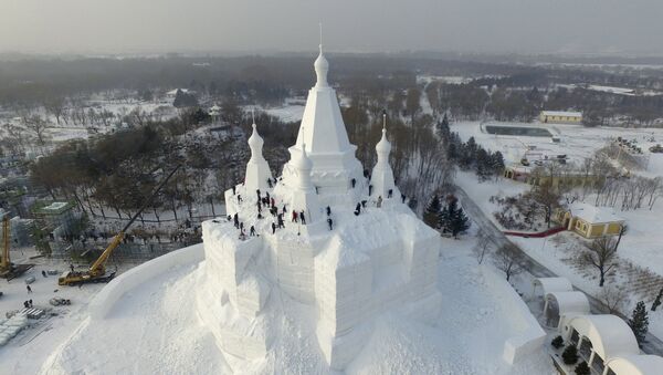 Workers polish a snow sculpture ahead of the annual Harbin International Ice and Snow Festival, in Harbin - Sputnik Mundo
