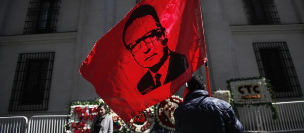 Un hombre alza la bandera con la cara de Salvador Allende frente al Palacio de La Moneda en Chile Un hombre alza la bandera con la cara de Salvador Allende frente al Palacio de La Moneda en Chile - Sputnik Mundo
