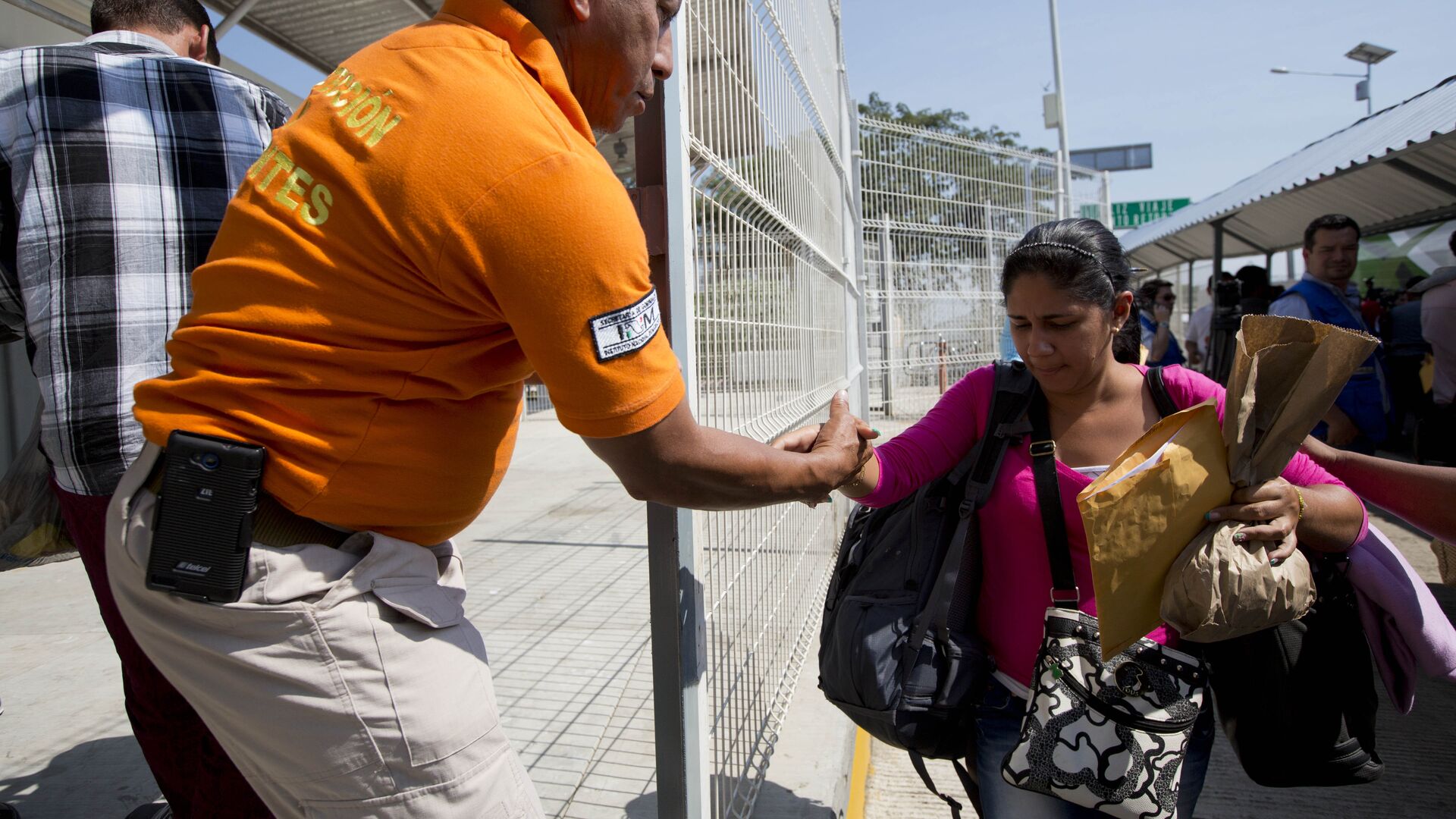 Un agent migratorio mexicano ofrece una mano a una migrante cubana cuando llega a Ciudad Hidalgo, México, en la frontera con Guatemala - Sputnik Mundo, 1920, 23.03.2021