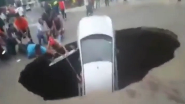 Un enorme hueco ”traga” un coche en Perú - Sputnik Mundo