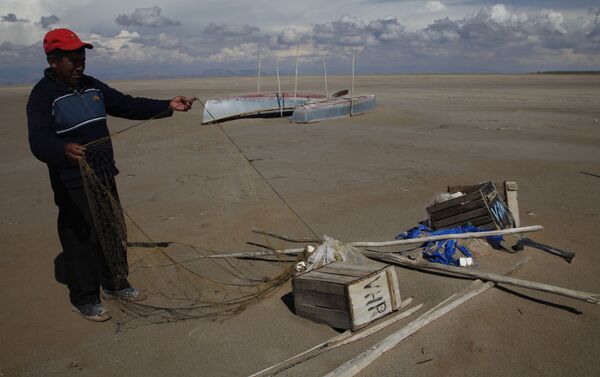 Un pescador mostrando las redes abandonadas en el desecado lago Poopó, Bolivia - Sputnik Mundo