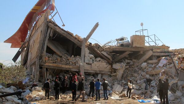 People gather around the rubble of a hospital supported by Doctors Without Borders (MSF) near Maaret al-Numan, in Syria's northern province of Idlib, on February 15, 2016 - Sputnik Mundo