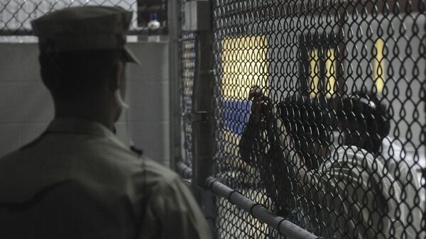 A Sailor assigned to the Navy Expeditionary Guard Battalion stands watch over detainees in a cell block in Camp 6 at Guantanamo Bay naval base in a March 30, 2010 file photo provided by the US Navy. - Sputnik Mundo