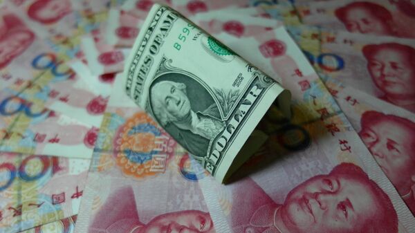 Yuan banknotes and US dollars are seen on a table in Yichang, central China's Hubei province on August 14, 2015 - Sputnik Mundo