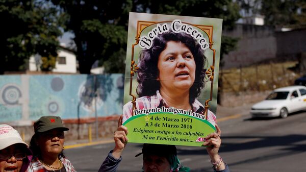 An activist holds up a photo of slain environmental rights activist Berta Caceres during a protest to mark International Women's Day outside the presidential house in Tegucigalpa - Sputnik Mundo