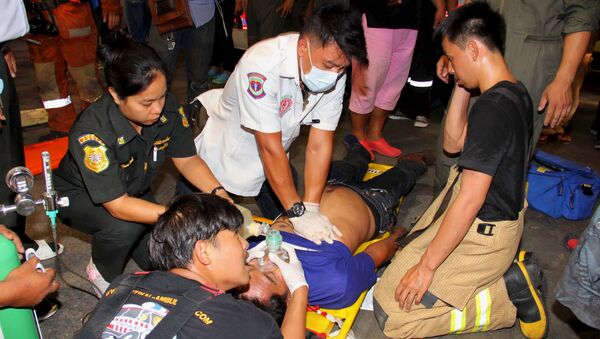 Socorristas tailandeses ayudan a un herido en un accidente en Bangkok - Sputnik Mundo