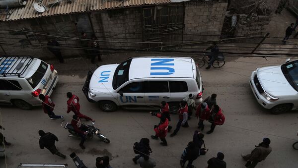 UN vehicles escorting a Red Crescent convoy carrying humanitarian aid arrive in Kafr Batna, in the rebel-held Eastern Ghouta area, on the outskirts of the capital Damascus on February 23, 2016 during an operation in cooperation with the UN to deliver aid to thousands of besieged Syrians - Sputnik Mundo