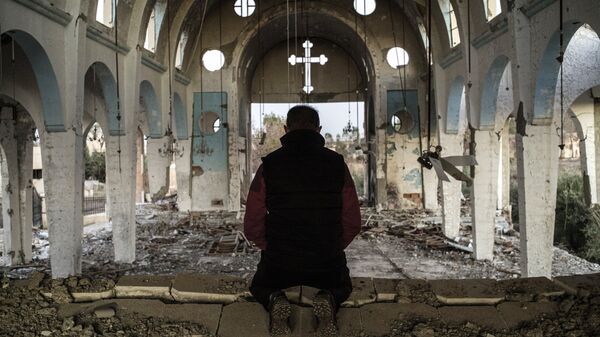 Cristiano sirio en una iglesia destruida en una aldea liberada de ISIS - Sputnik Mundo