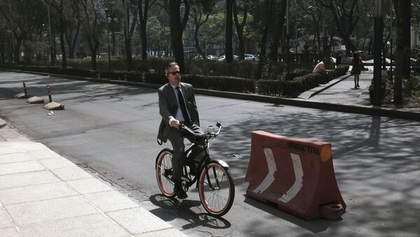 Un hombre en bicicleta durante la jornada bajo contingencia por contaminación en la Ciudad de México - Sputnik Mundo