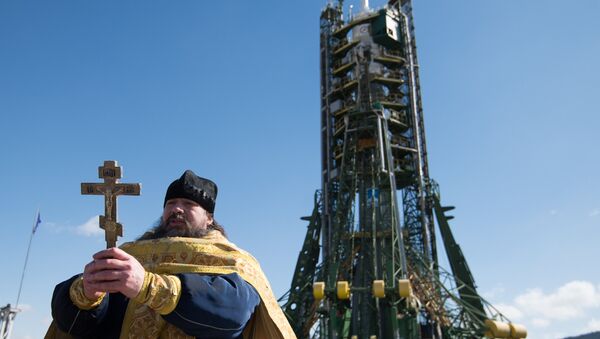 Un sacerdote ortodoxo durante la ceremonia de bendición del cohete-portador  Soyuz-FG en el cosmódromo de Baikonur - Sputnik Mundo