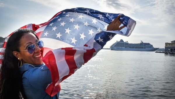 A Cuban waves a US flag at the Malecon waterfront as the first US-to-Cuba cruise ship to arrive in the island nation in decades glides into the port of Havana, on May 2, 2016. - Sputnik Mundo