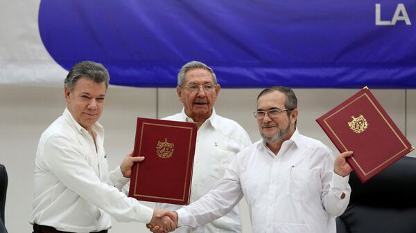 Cuba's President Raul Castro, Colombia's President Juan Manuel Santos and FARC rebel leader Rodrigo Londono react after signing a historic ceasefire deal between the Colombian government and FARC rebels in Havana - Sputnik Mundo