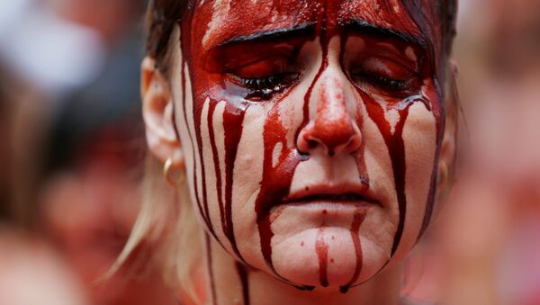 Manifestante cubierta de 'sangre' durante las protestas contra los encierros en las tradicionales celebraciones regionales de San Fermín. Pamplona, España, 5 de julio de 2016. - Sputnik Mundo