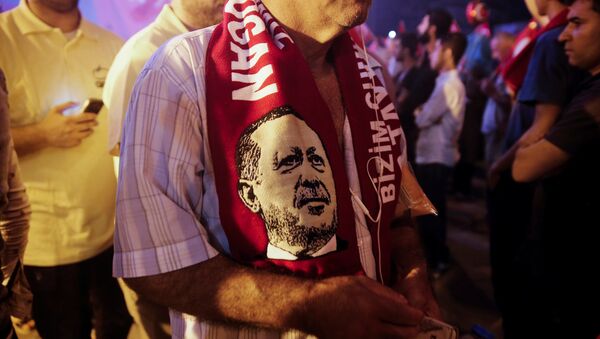 Simpatizante del presidente de Turquía,Tayyip Erdogan, con una bufanda con su imagen - Sputnik Mundo