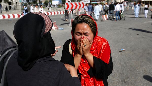 Una mujer afgana llora en el sitio de atentado en Kabul - Sputnik Mundo