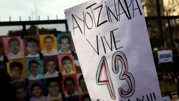 A woman holds up a sign that reads Ayotzinapa lives - 43 are missing - Sputnik Mundo